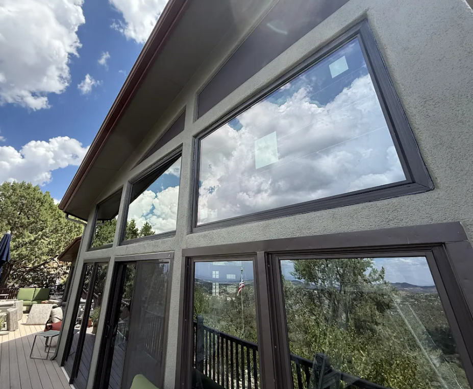 Large black-framed picture windows installed on a hillside home