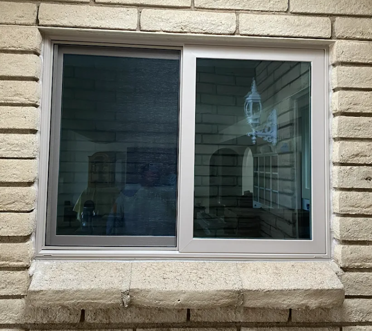 Exterior view of a replacement window fitted into a brick wall