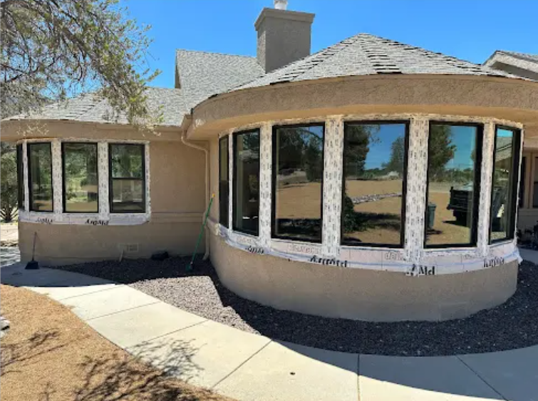 A curved window bay with multiple new black-framed windows