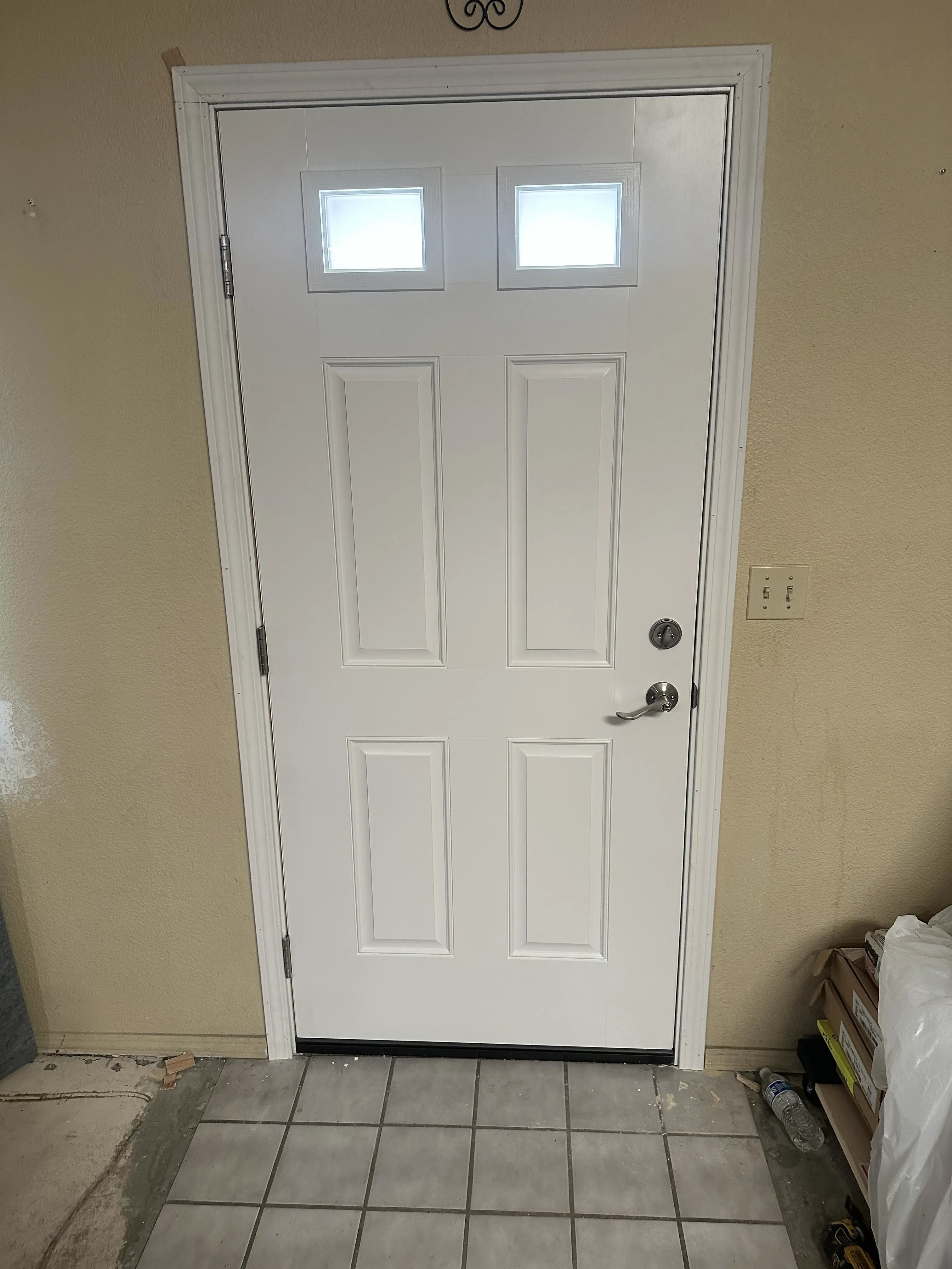 Interior view of a new white entry door with two square windows
